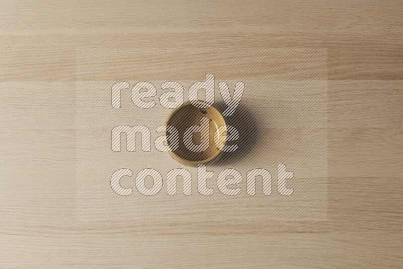 A multicolored pottery bowl on light wooden background