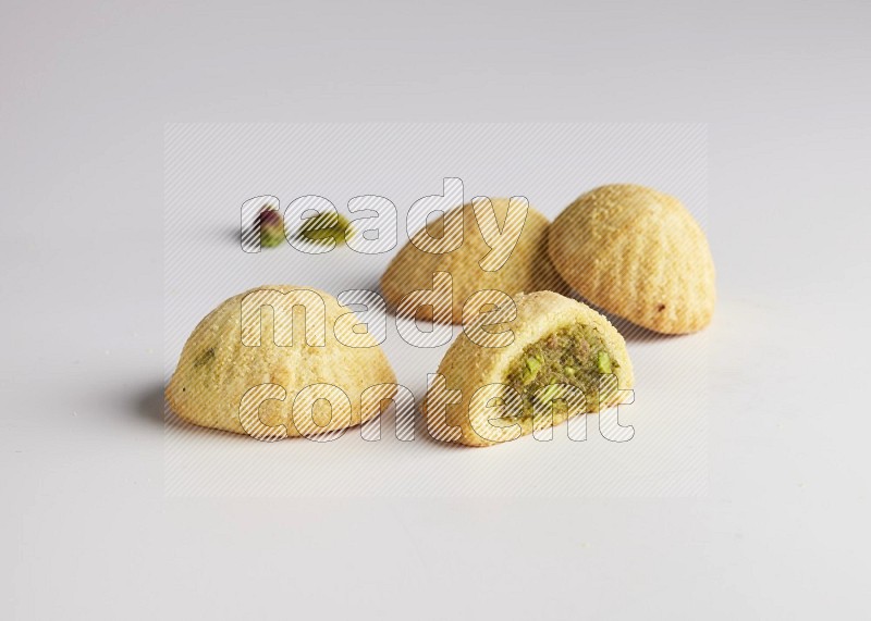 Four Pieces of Maamoul filled with pistachio  paste one of them is cut direct on white background