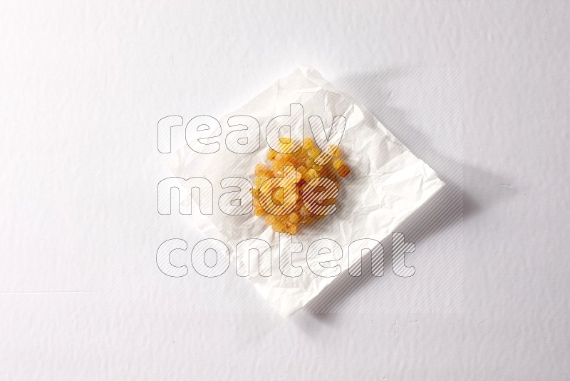 Raisins on a crumpled piece of paper on a white background in different angles