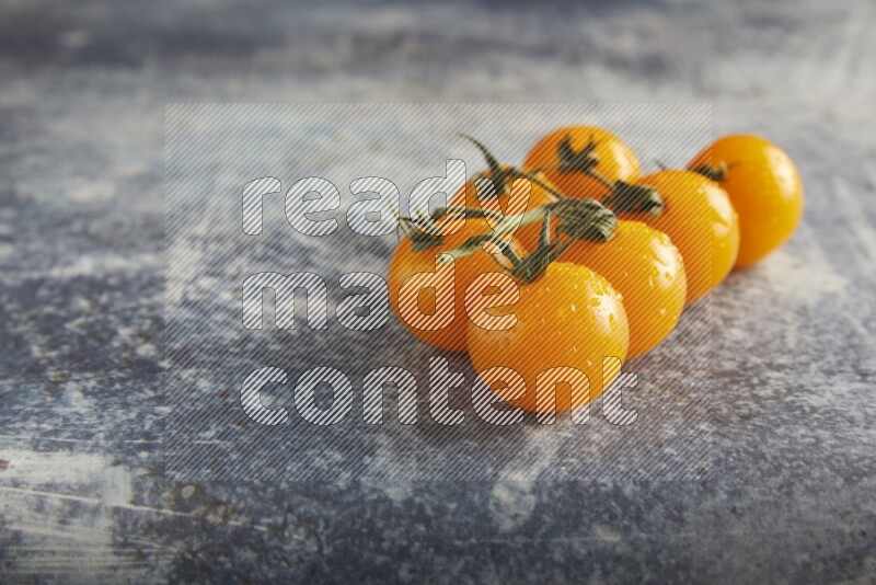 yellow cherry tomato vein on a textured rusty blue background 45 degree