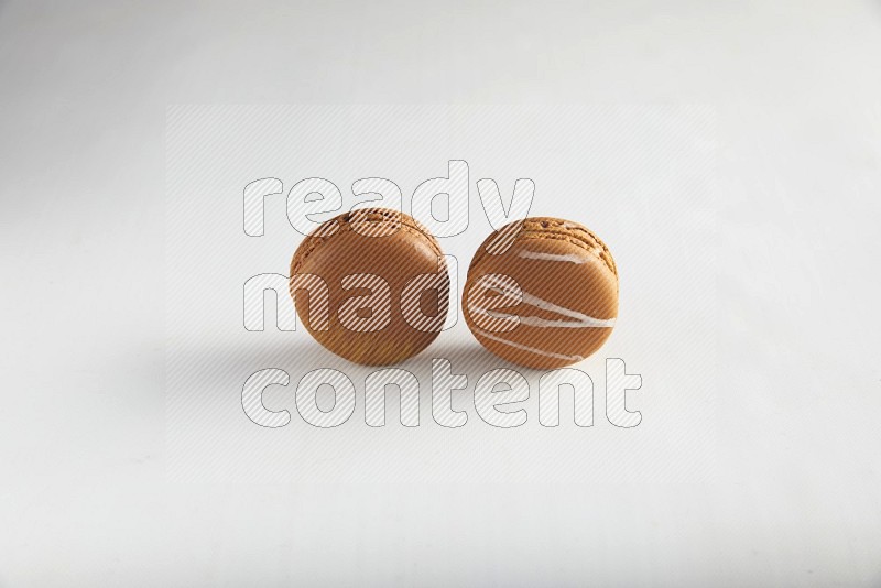 45º Shot of of two assorted Brown Irish Cream, and Brown Coffee macarons  on white background