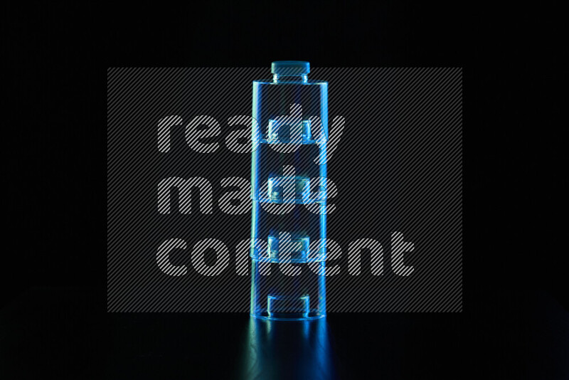 Glassware with rim light in blue and green against black background