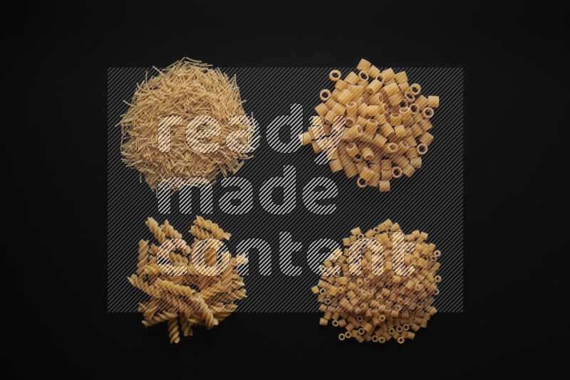 Different pasta types in bunches on black background