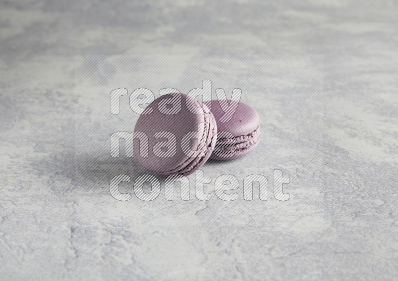 45º Shot of two Purple Blueberry macarons  on white  marble background