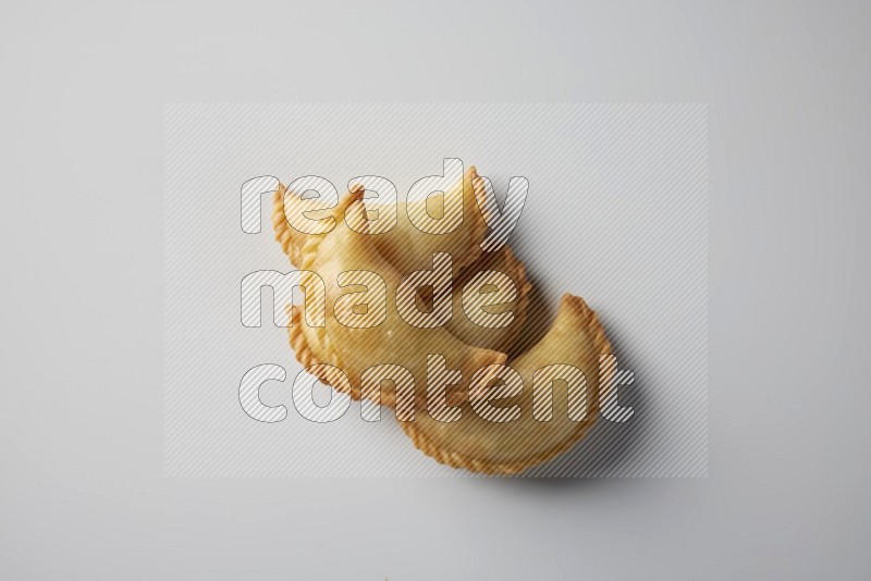 Four fried sambosa from a top angle on a white background