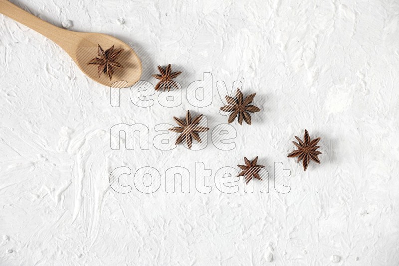 Star Anise in a wooden spoon on white flooring