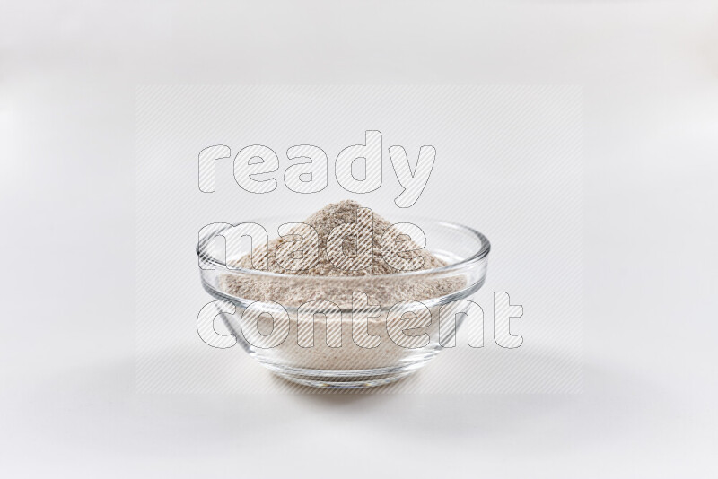 A glass bowl full of onion powder on white background