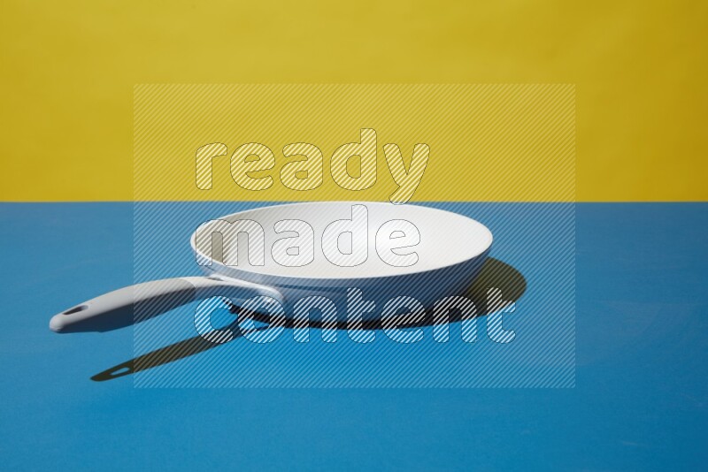 white pan on yellow and Blue background