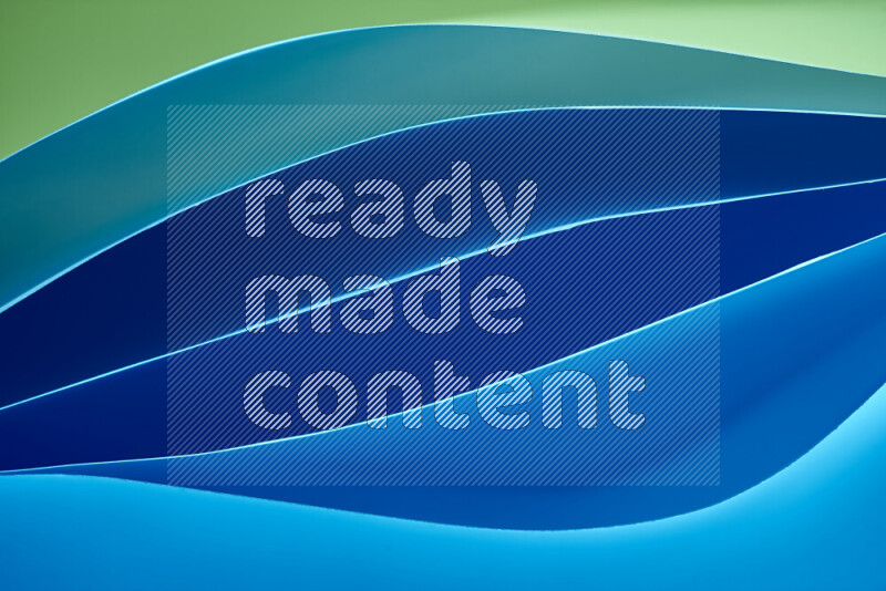 هذه الصورة تعرض تكوين فن الورق التجريدي مع منحنيات ورقية بتدرجات اللون الأخضر والأزرق المكونه بواسطة الضوء الملون