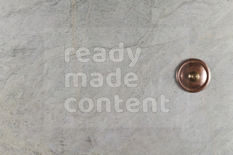 A small copper pot on grey marble background