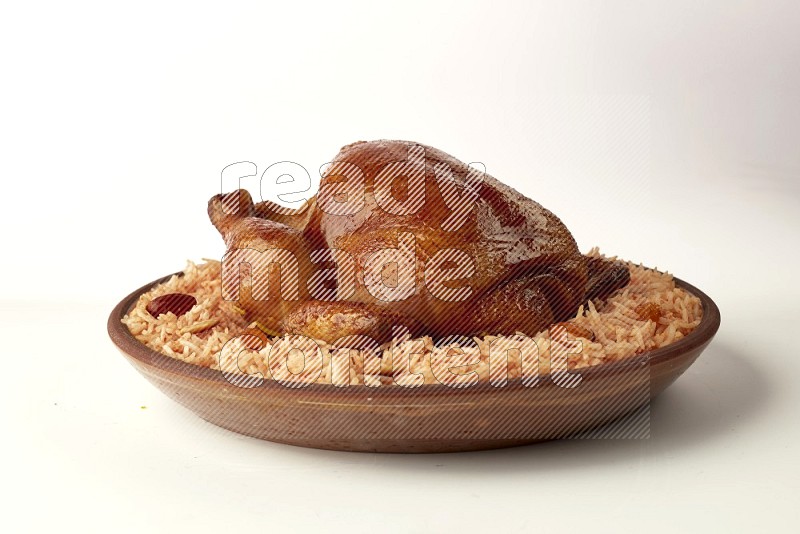 red basmati Rice with whole roasted chicken on a pottery plate direct on white background