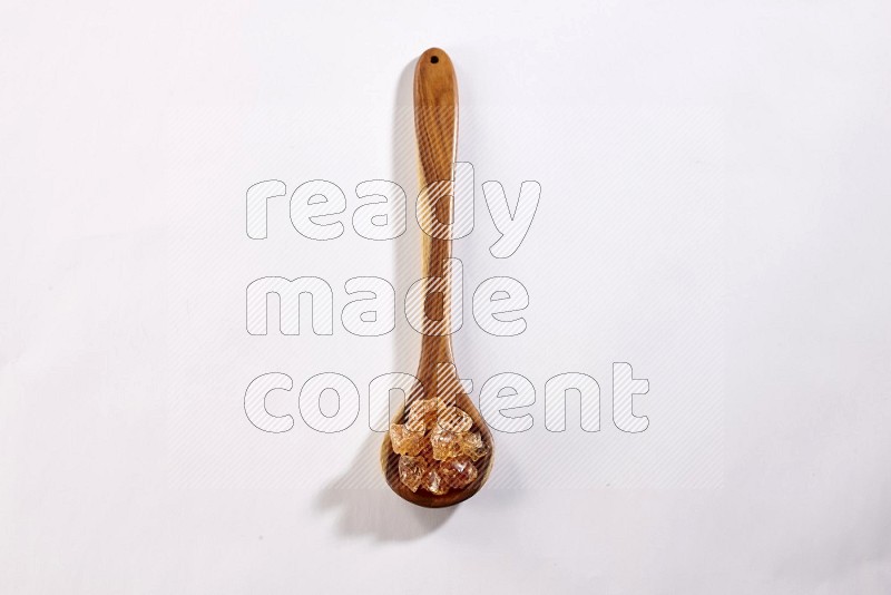 A wooden ladle filled with gum arabic on white flooring in different angles