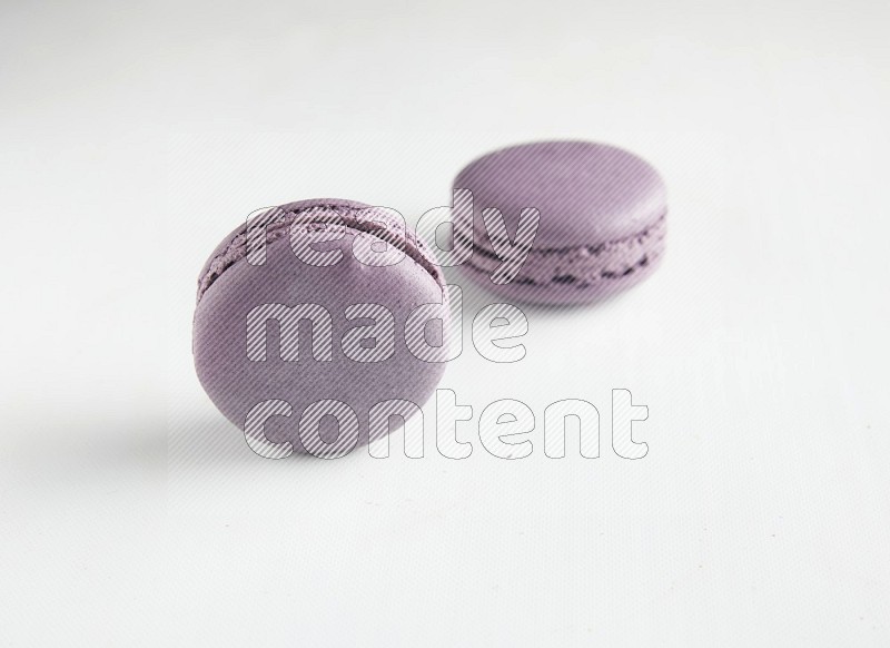 45º Shot of two Purple Blueberry macarons on white background