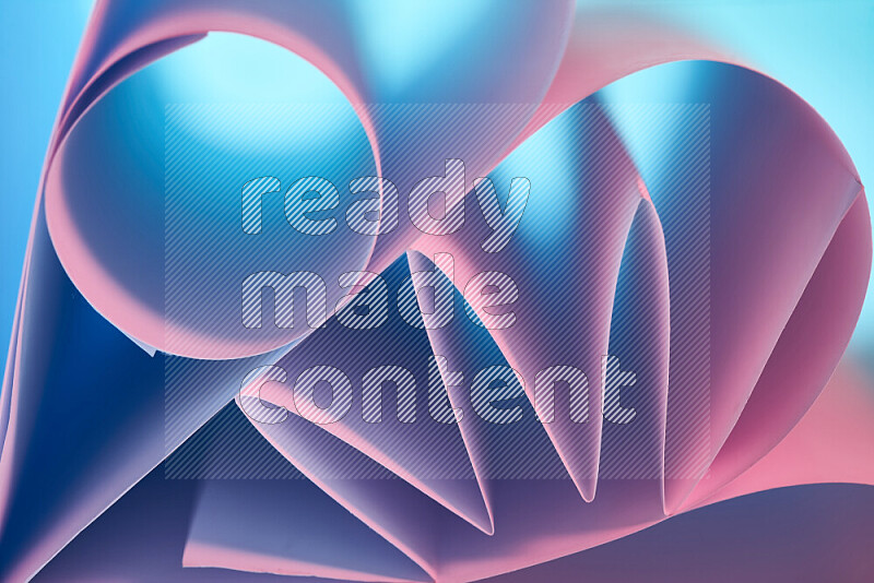 عرض فني لطيات الورق تخلق مزيج من الأشكال الهندسية، مضاءة بإضاءة ناعمة بدرجات اللون الأزرق والوردي