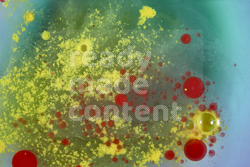The image captures a dramatic splatter of red, green and yellow paints over the backdrop