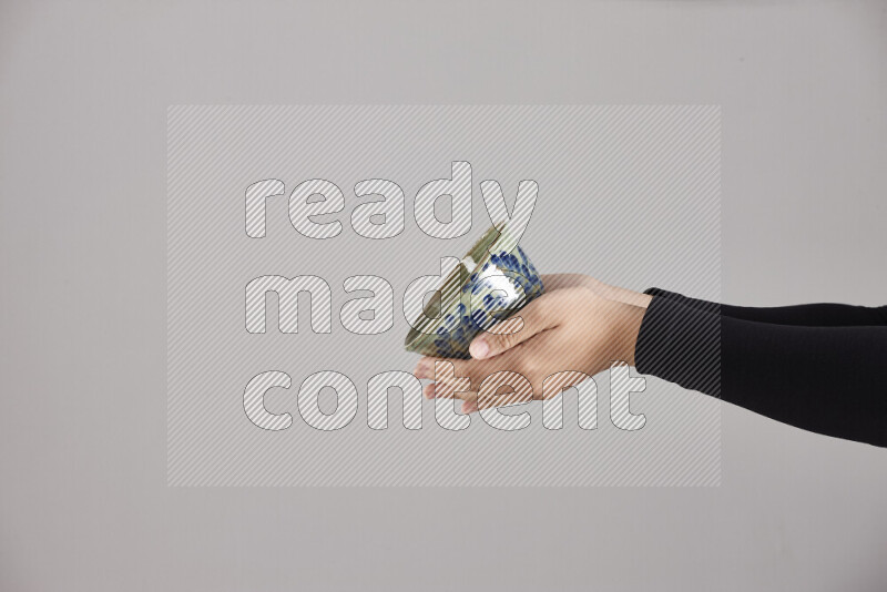 A woman in black abaya holding different pottery essentials in different positions