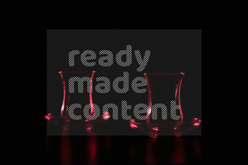 Glassware with rim light in red against black background