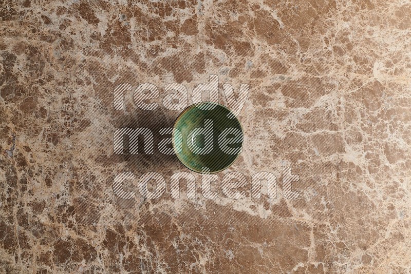 Top View Shot Of A Dark Green Pottery Bowl On beige Marble Flooring