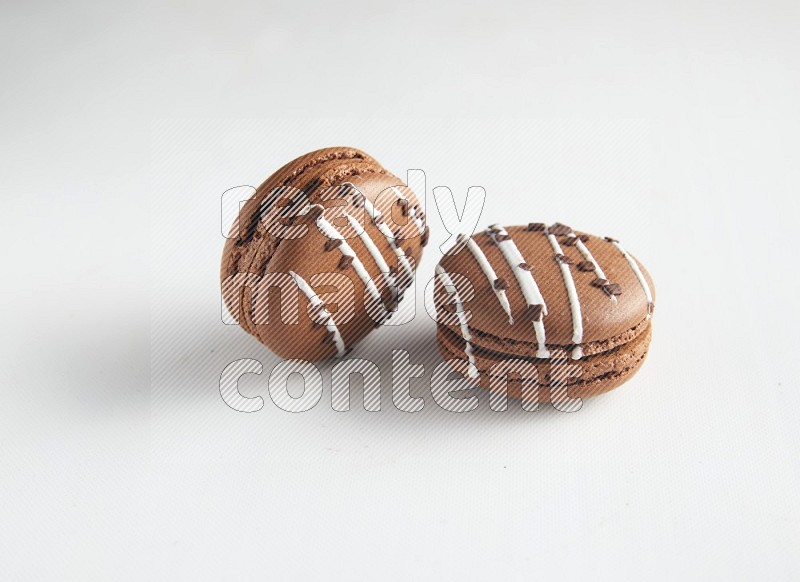 45º Shot of two Brown white Chocolate Caramel macarons on white background