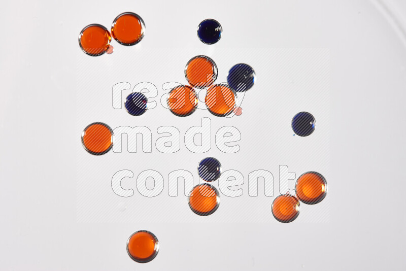 Close-ups of abstract red and blue watercolor drops on oil Surface on white background
