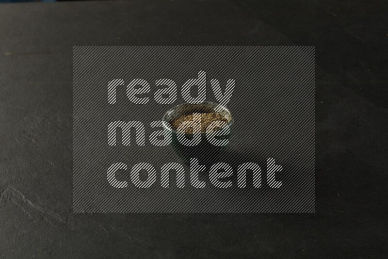 multi color round sauce bowl filled with herbs on grey textured countertop