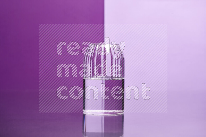 The image features a clear glassware filled with water, set against purple and light purple background