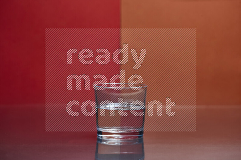 The image features a clear glassware filled with water, set against red and dark orange background