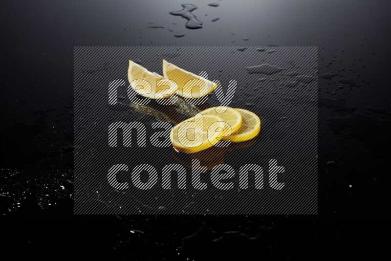 Lemon slices with water drops, and droplets on black background