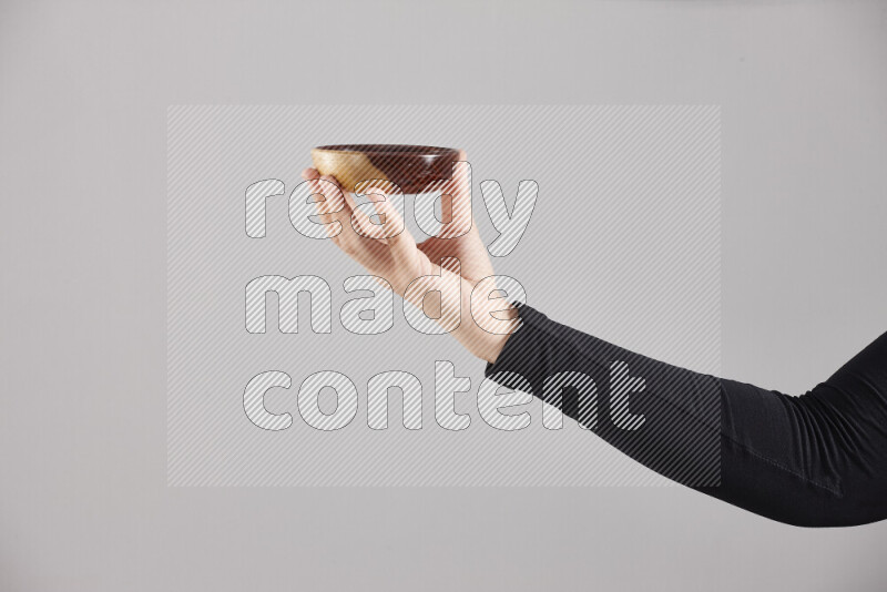 امرأة ترتدي عباءة سوداء تحمل أدوات خشبية مختلفة في أوضاع متعددة