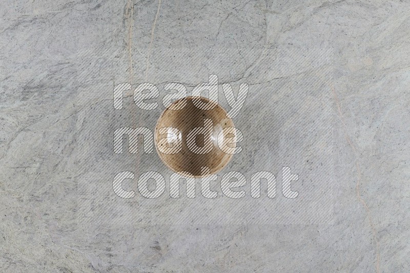 Top View Shot Of A Beige Pottery Bowl On Grey Marble Flooring