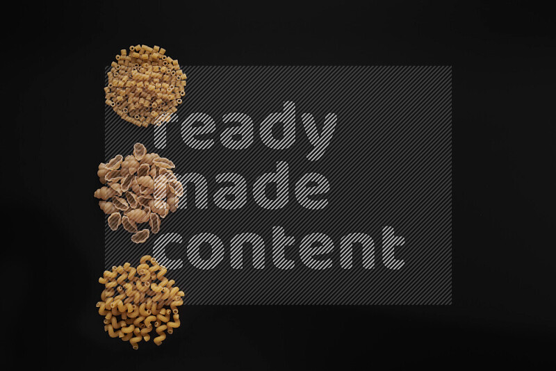 Different pasta types in 3 bunches on black background