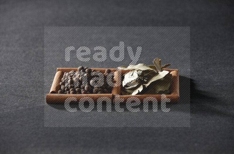 2 squares of cinnamon sticks full of allspice and bay laurel leaves on black flooring
