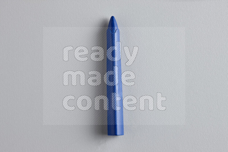 A close-up showing a single wax crayon on grey background