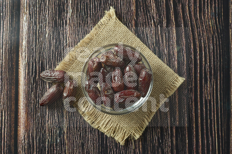 Dates in different bowls (wooden, pottery and glass) on wooden background