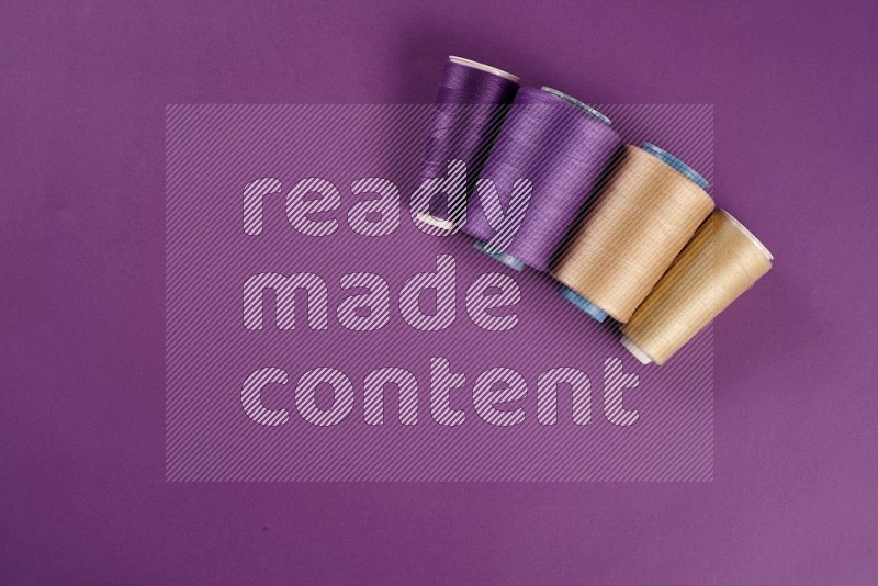 Beige sewing supplies on purple background