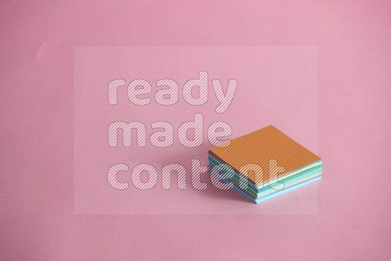 Stacked multicolored sticky notes on rose background