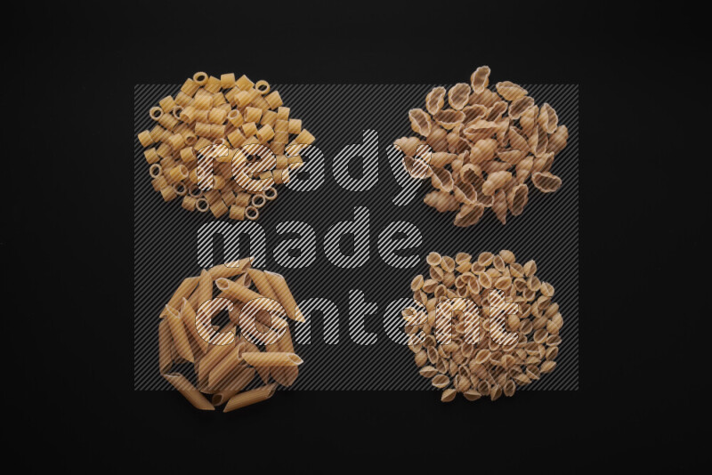 Different pasta types in bunches on black background