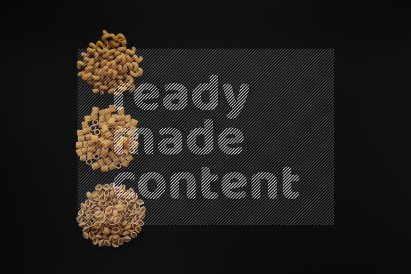 Different pasta types in 3 bunches on black background