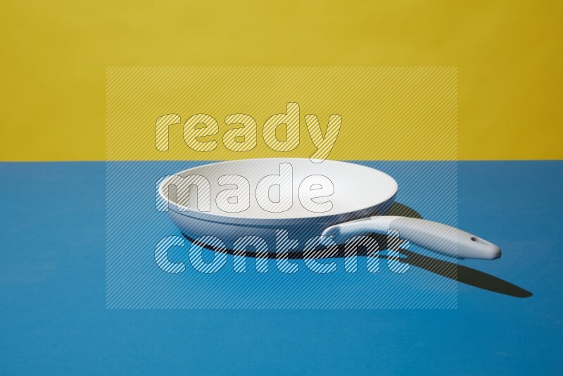 white pan on yellow and Blue background