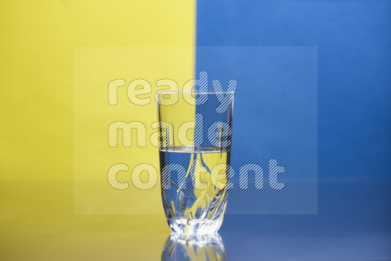 تظهر الصورة أواني زجاجية ممتلئة بالماء موضوعة على خلفية من اللونين الأصفر والأزرق