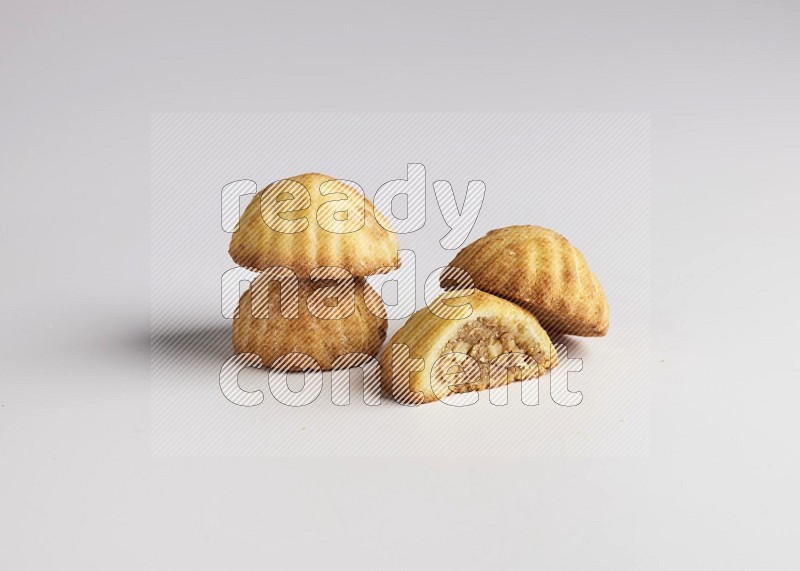 Four Pieces of Maamoul filled with walnut paste  one of them is cut direct on white background