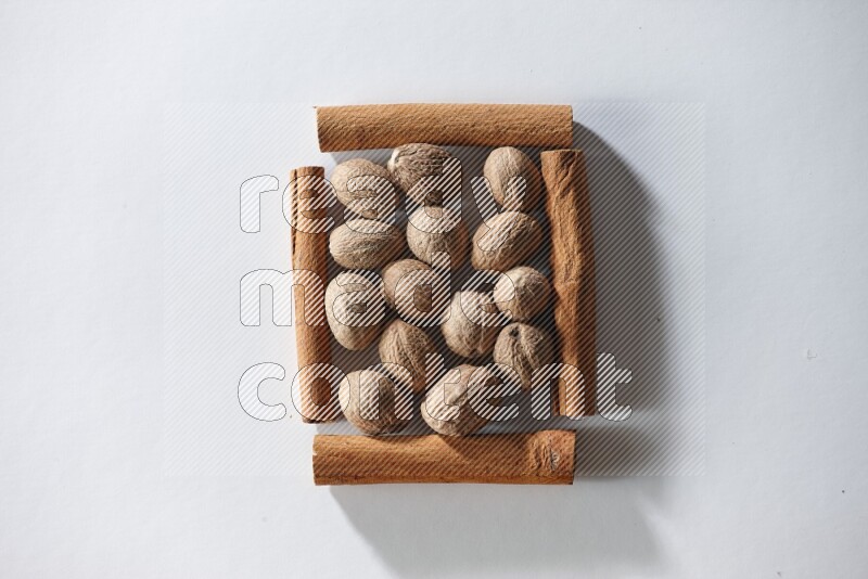 A single square of cinnamon sticks full of nutmeg on white flooring