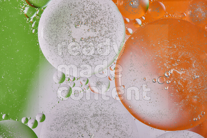 لقطات مقربة لفقاعات من الزيت على سطح الماء باللون البرتقالي والأخضر والأبيض
