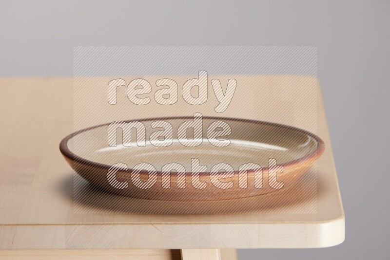 multi-colored pottery Plate on a wooden table edge