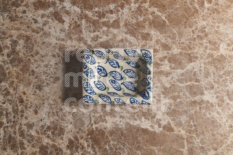 A decorative pottery plate on beige marble background