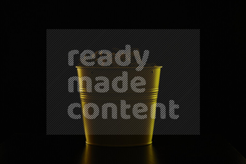 A plant pot with colored rim light against black background