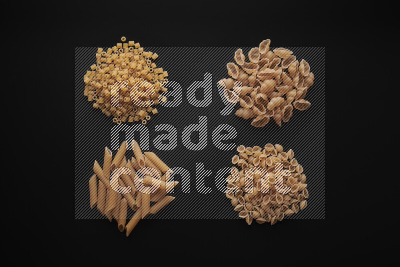 Different pasta types in bunches on black background