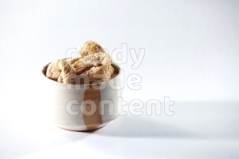 A beige ceramic bowl full of dried figs on a white background in different angles