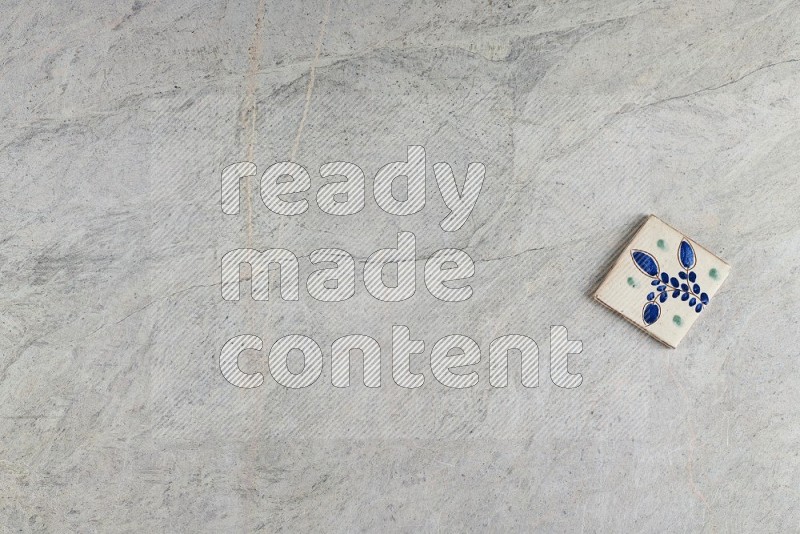 Top View Shot Of A Pottery Coaster tile On Grey Marble Flooring