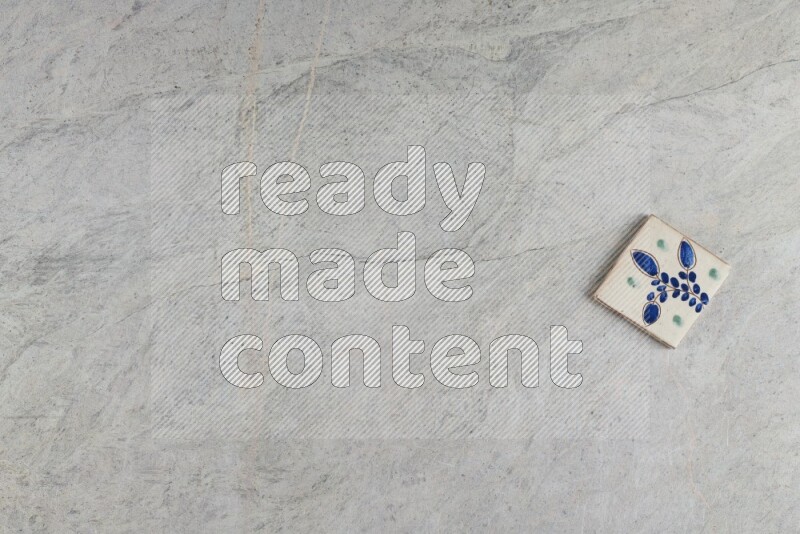 A decorative pottery coaster on grey marble background